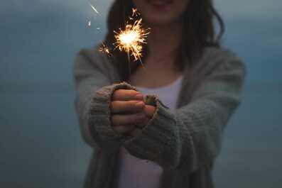Woman holding sparkler at night. With CBT therapy, you can overcome anxiety and OCD.